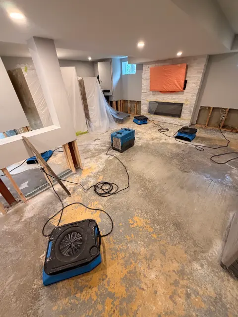Finished basement with the lower drywall cut out and air movers running