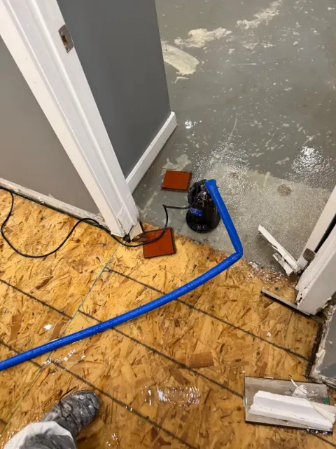 Pump hose drawing water off a wet subfloor