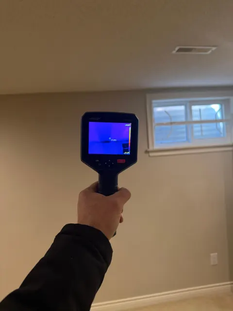Thermal camera scan of a finished basement wall below a window