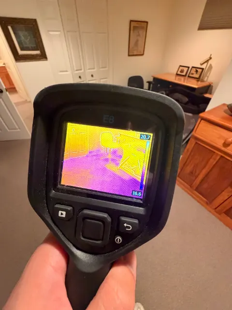 Thermal camera scanning a room for hidden moisture